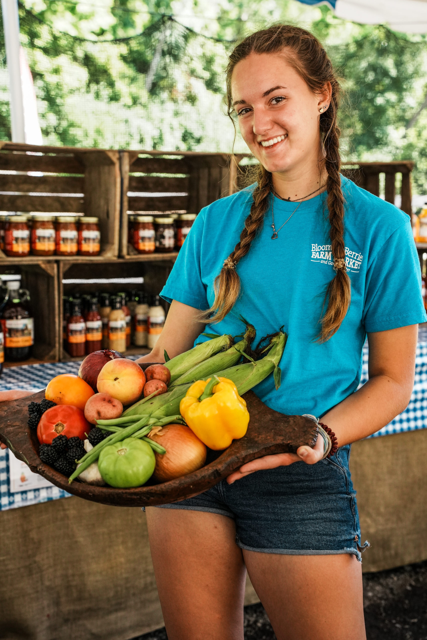 summer_market-center_produce_employee-smile-holding-fruit_2023